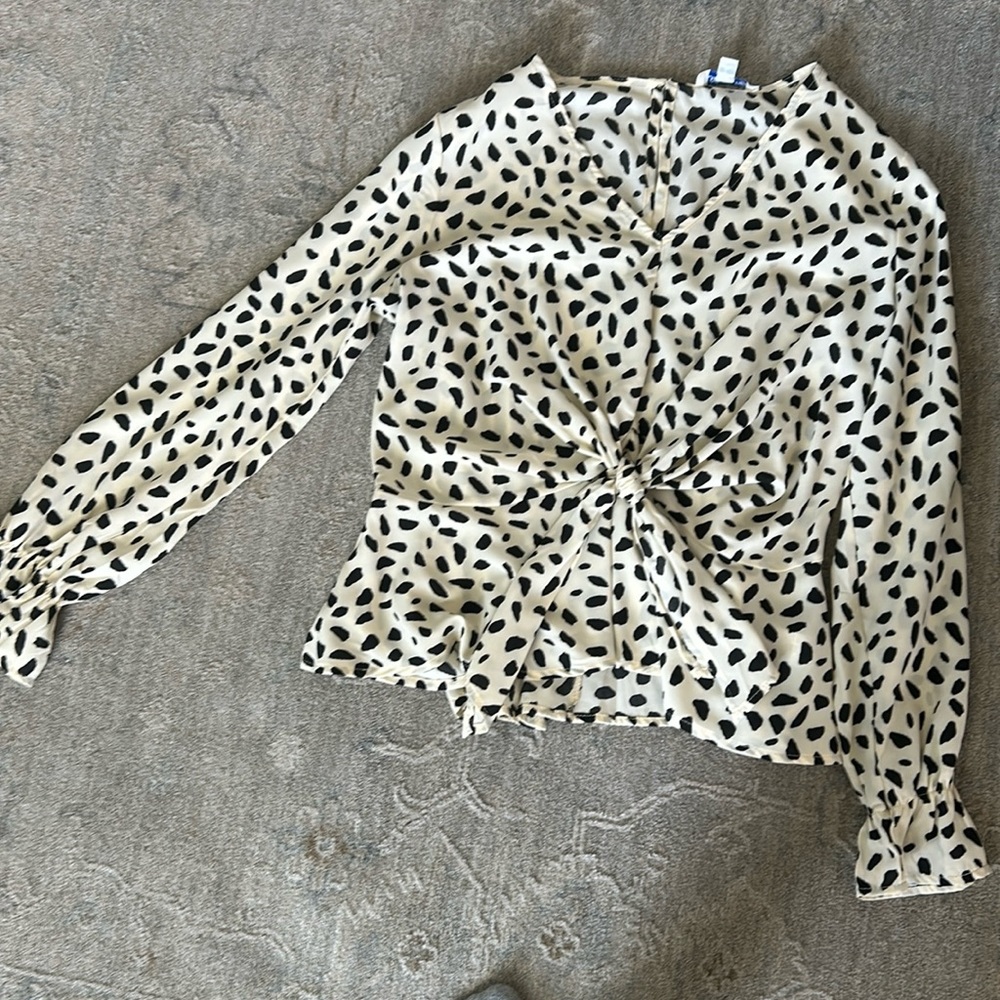 Cream and black blouse. Elastic around wrist. One button in back.